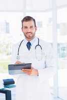 Portrait of a confident male doctor with clipboard