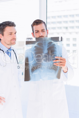 Male doctors examining x-ray in medical office