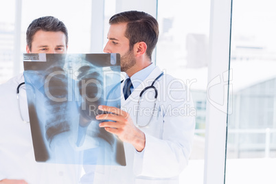 Two male doctors examining x-ray