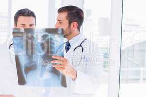 Two male doctors examining x-ray