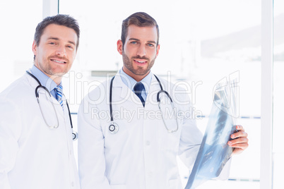 Portrait of two male doctors examining x-ray