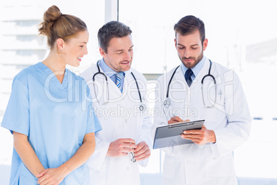 Doctors and female surgeon reading medical reports