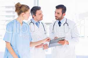 Doctors and female surgeon reading medical reports