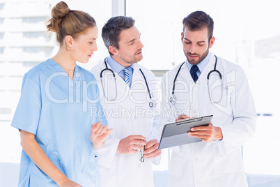 Doctors and female surgeon reading medical reports