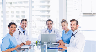 Smiling medical team around desk in office