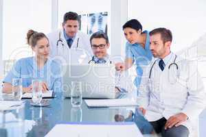 Concentrated medical team using laptop together