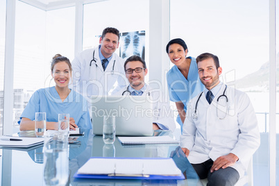 Happy medical team using laptop together