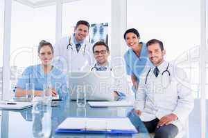 Happy medical team using laptop together