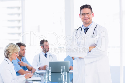 Smiling doctor with colleagues in meeting