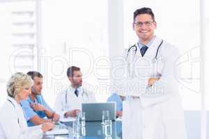Smiling doctor with colleagues in meeting
