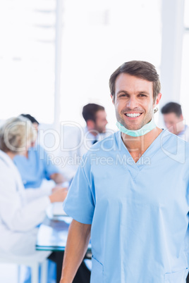 Smiling male surgeon with colleagues in meeting