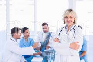Smiling female doctor with colleagues in meeting