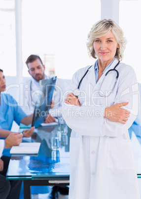 Smiling female doctor with colleagues in meeting