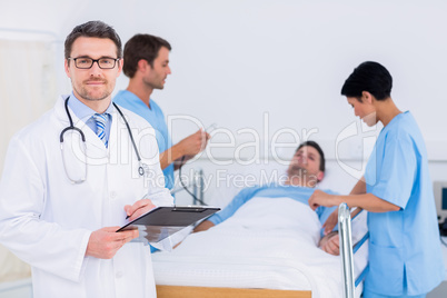 Doctor holding reports with patient and surgeon in background