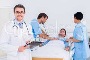 Doctor holding reports with patient and surgeon in background