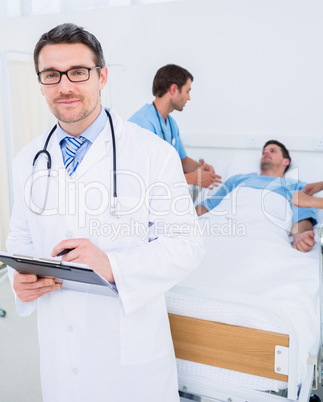 Doctor holding reports with patient and surgeon in background