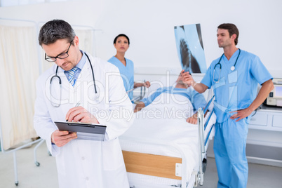 Doctors holding reports by patient at hospital