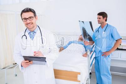 Doctors holding reports by patient at hospital