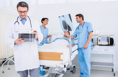 Doctors holding reports by patient at hospital