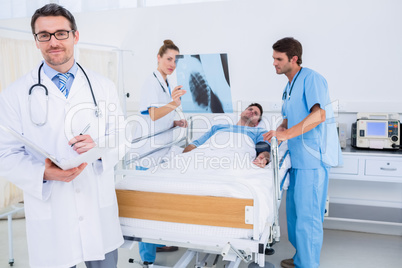 Doctors holding reports by patient at hospital