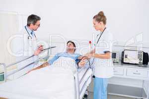 Doctors visiting a male patient in hospital