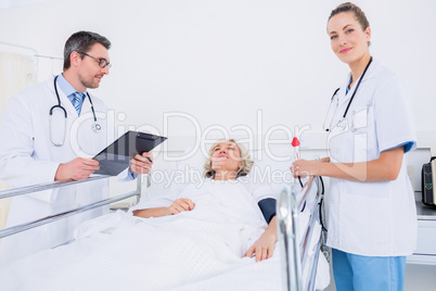 Doctors visiting a female patient in hospital