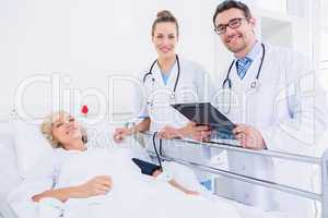 Doctors visiting a female patient in hospital