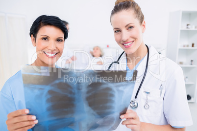 Portrait of a smiling doctor and surgeon examining x-ray