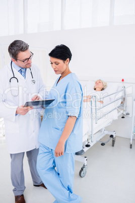 Doctors discussing reports with patient in hospital