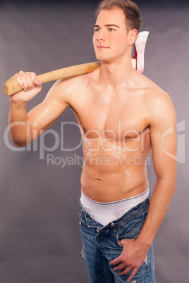 Sexy muskulöser junger Mann beim hacken von Brennholz