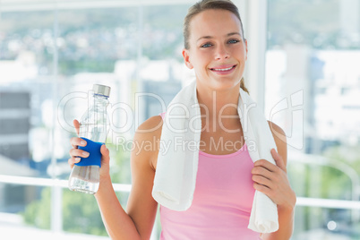 Woman with towel and water bottle in gym