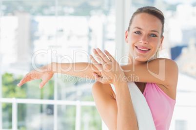 Sporty young woman stretching hands at yoga class