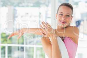 Sporty young woman stretching hands at yoga class