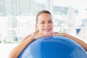 Smiling fit woman with exercise ball at gym
