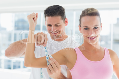 Smiling young man measuring womans arm
