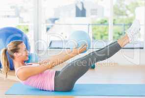 Sporty young woman stretching body in fitness studio