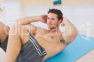 Determined young man doing abdominal crunches