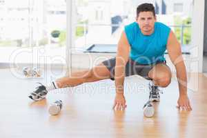 Full length portrait of a sporty man doing stretching exercise
