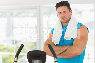 Serious young man working out at spinning class