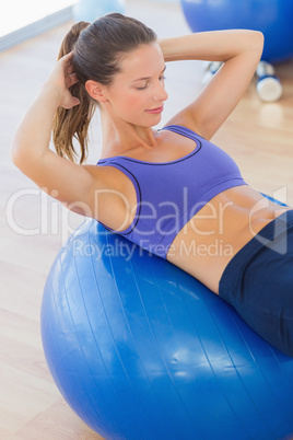 Fit woman exercising on fitness ball