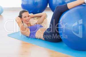 Fit young woman exercising on fitness ball