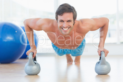 Portrait of a smiling young man doing push ups