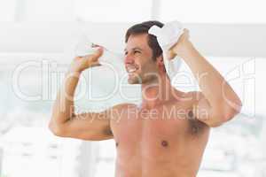 Smiling shirtless man with towel in gym