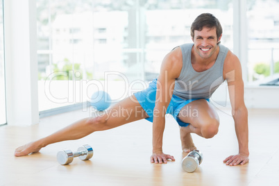 Sporty man doing stretching exercise in fitness studio