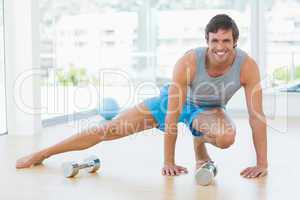 Sporty man doing stretching exercise in fitness studio