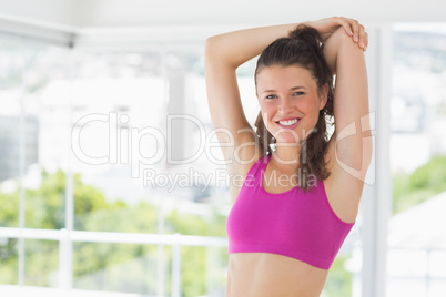 Sporty young woman stretching hands at yoga class