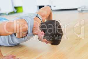 Determined man doing push ups in gym