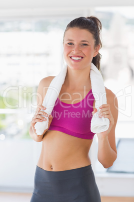 Portrait of a smiling fit woman with towel in gym