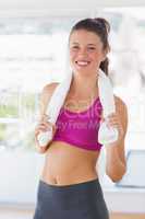 Portrait of a smiling fit woman with towel in gym