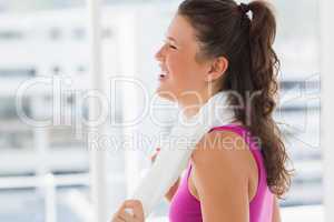 Smiling fit young woman with towel in gym